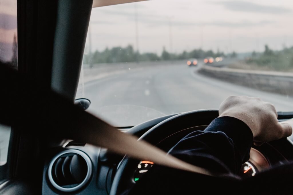 Close up of a man driving a car / road